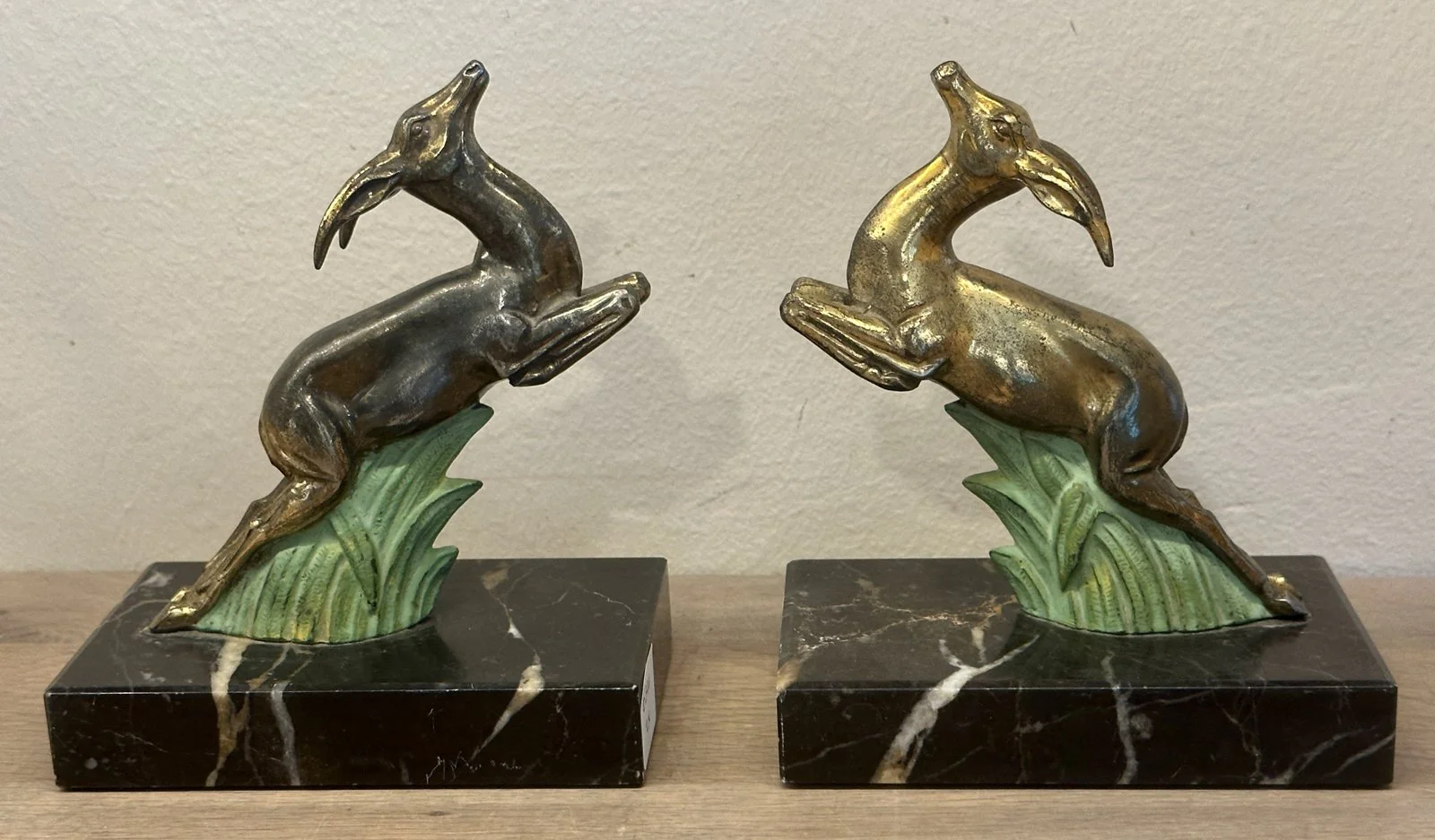 Boekensteunen – 2 stuks – uitgevoerd in een zwart marmeren voet met hert/ree in spelt