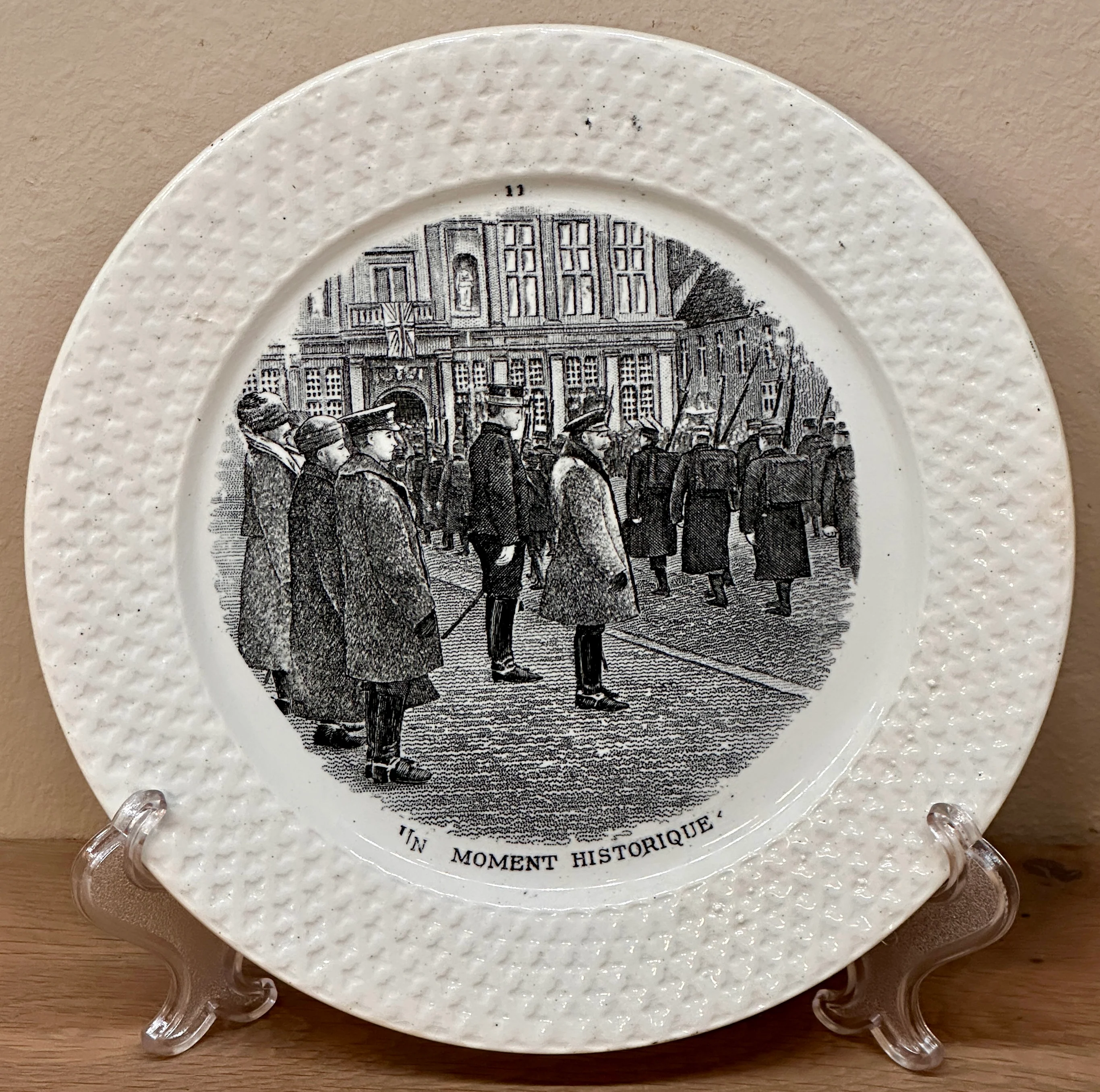 Dessert bord / Sierbord – Societe Ceramique Maestricht – uitgevoerd in zwart/wit met reliëf rand en opschrift “Un moment historique”