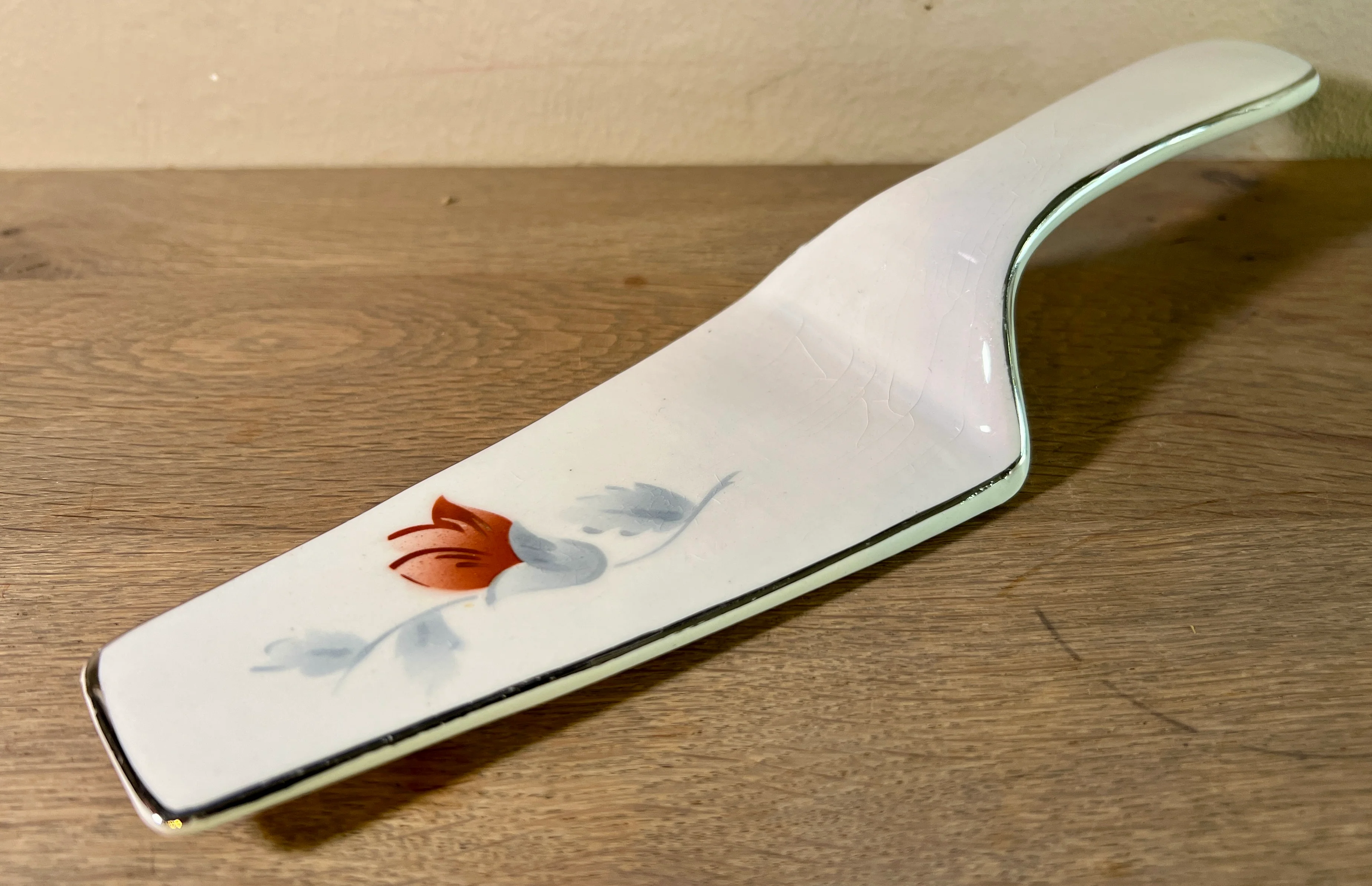 Taartschep – ongemerkt – décor met grijs/witte bladeren en een rood/paarse bloem