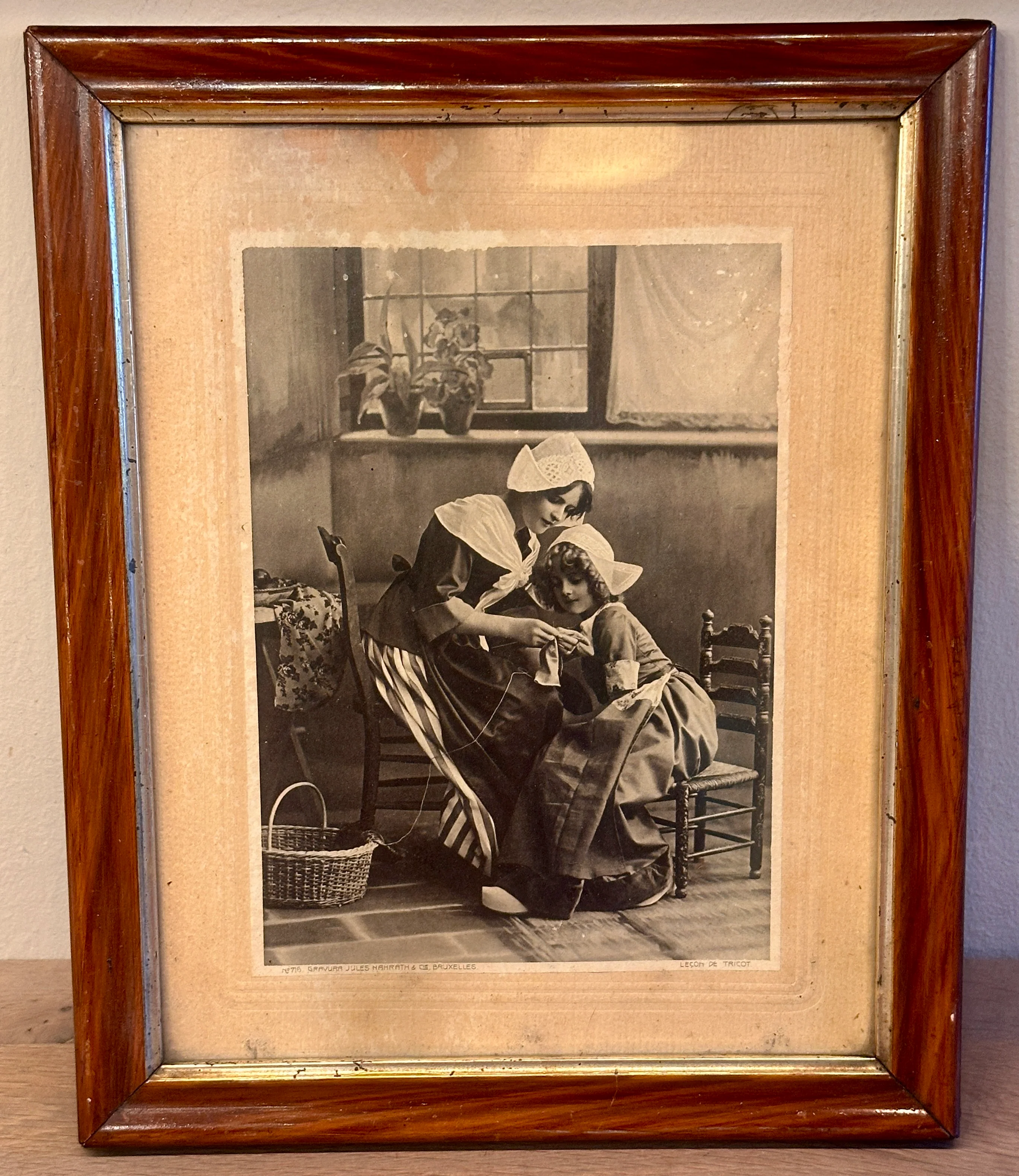 Print van een gravure van Jules Nahrath & Cie. Bruxelles – ‘Leçon de tricot’ (de breiles) – vrouw die meisje leert breien